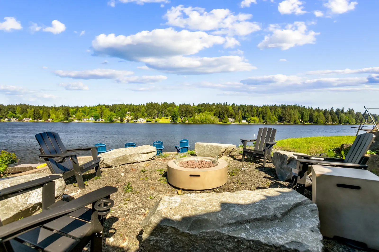 Outdoor chairs and gas fire pit with lake view